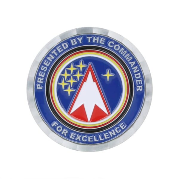 Circular emblem with Presented by the Commander for Excellence around the edge. In the center, a red and white arrowhead shape is surrounded by stars on a blue background.