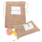 Two burlap bags with drawstrings, one upright labeled RANDOM and the other lying down. Two fruits, resembling a peach and an orange, are partially visible emerging from the lying bag.