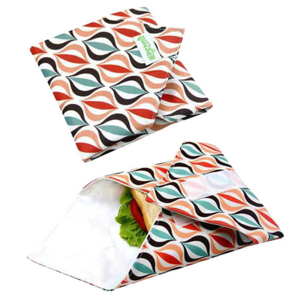 Reusable sandwich wraps with a colorful geometric leaf pattern in orange, red, and black. One wrap is open, showcasing a sandwich with lettuce and tomato inside. The other wrap is folded and closed, displaying a small logo tag.