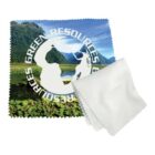 A microfiber cloth with an image of mountains and a lake, featuring the text Green Resources in a circular design. A plain white cloth is folded next to it.