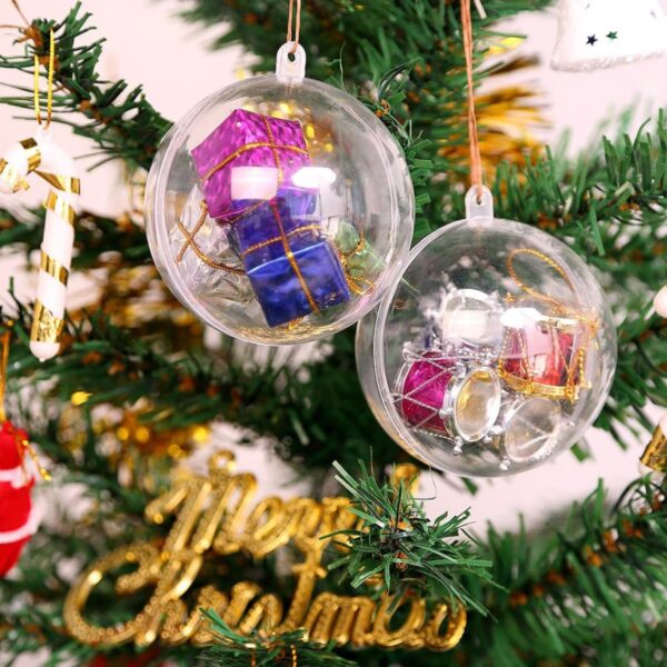 Clear ornaments with colorful gifts and drums inside hang on a Christmas tree. A Merry Christmas sign is in the background, along with other festive decorations like candy canes and baubles.