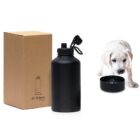 A black water bottle with a flip top is shown next to its packaging box on the left. On the right, a small white puppy is drinking from a matching black bowl.
