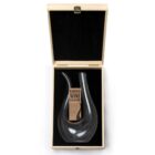 A sleek, curved glass wine decanter labeled Barolo Wine Decanter is displayed in an open wooden box lined with black fabric.