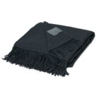 A folded dark green wool blanket with fringed edges on one side. A small rectangular tag is visible on the blanket.