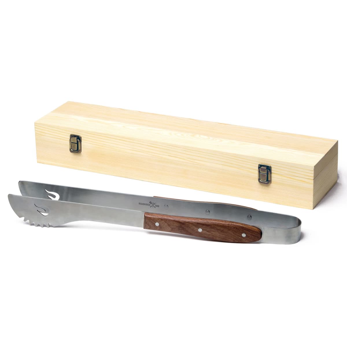 BBQ tongs with a wooden handle and serrated edges are displayed in front of a light-colored wooden storage box with metal clasps. The tongs are positioned diagonally above the box.