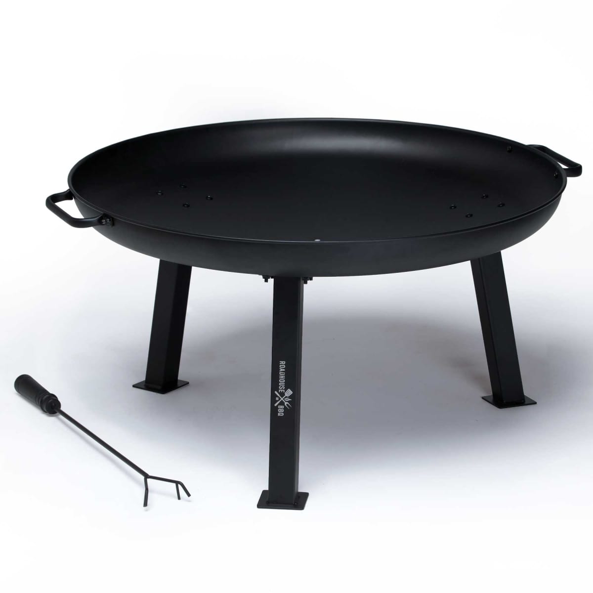 A large, black metal fire pit with three sturdy legs and two side handles. It is accompanied by a long metal poker for adjusting logs or coals. The fire pit has a wide, shallow bowl design suitable for outdoor use.