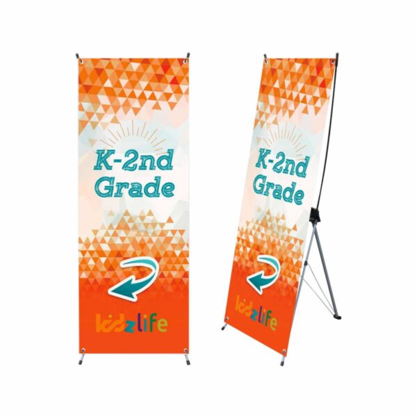Two retractable banners for K-2nd Grade with colorful orange and white geometric patterns, featuring a sunburst design. A white arrow points right, and kidzlife is at the bottom in orange and blue letters.