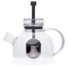 A transparent glass teapot with a modern design features a built-in metallic infuser and a sleek handle. The lid has a black plunger-style knob, complementing its contemporary appearance.