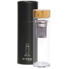 A transparent glass tea infuser bottle with a wooden lid is displayed next to its black cylindrical packaging. The bottle includes a metal strainer inside, and the packaging displays the brand name po di fame with details.