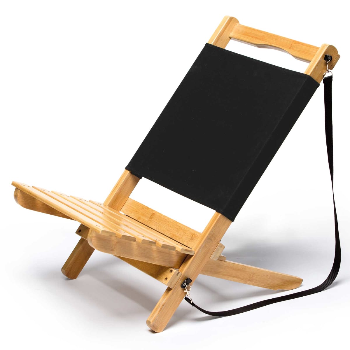 A folding wooden chair with a black fabric backrest and a shoulder strap is positioned against a white background. The chair features a slatted seat design and a sturdy frame.