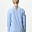 Person with blonde hair in a ponytail wearing a light blue long-sleeve shirt, seen from behind.