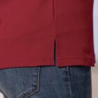 Close-up of a person wearing a red shirt and blue jeans.