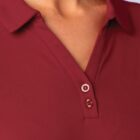 Close-up of a person wearing a maroon collared shirt with two visible buttons.