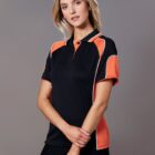 Person wearing a black and orange polo shirt against a gray background.