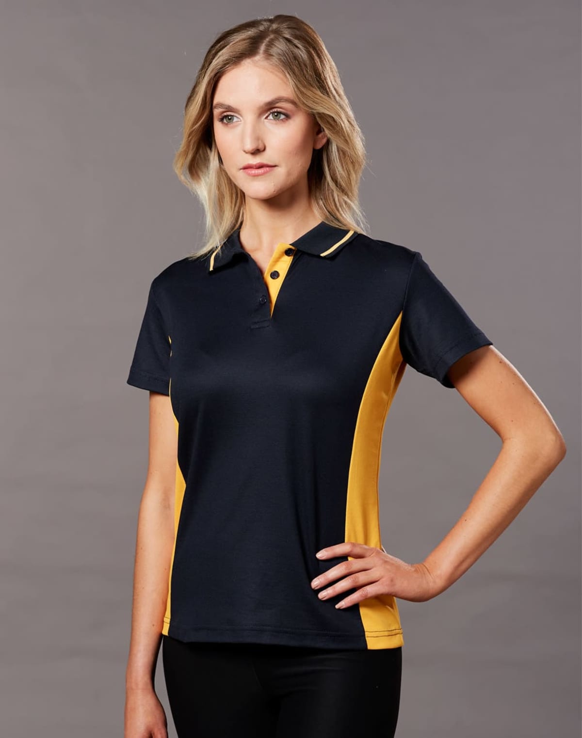 Person wearing a black and yellow polo shirt against a gray background.