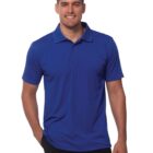 Man in a blue polo shirt and black pants smiling at the camera.
