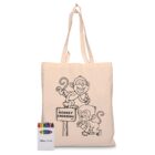 A beige tote bag displays an outline drawing of two cartoon monkeys, one holding a banana, near a sign that reads Monkey Crossing. A small pack of colored crayons is placed beside the bag.