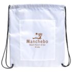 A white drawstring backpack with black cords features a front pocket. The pocket displays a brown logo with a stylized wave, sun, and palm tree, and reads Manchebo Beach Resort & Spa Aruba.