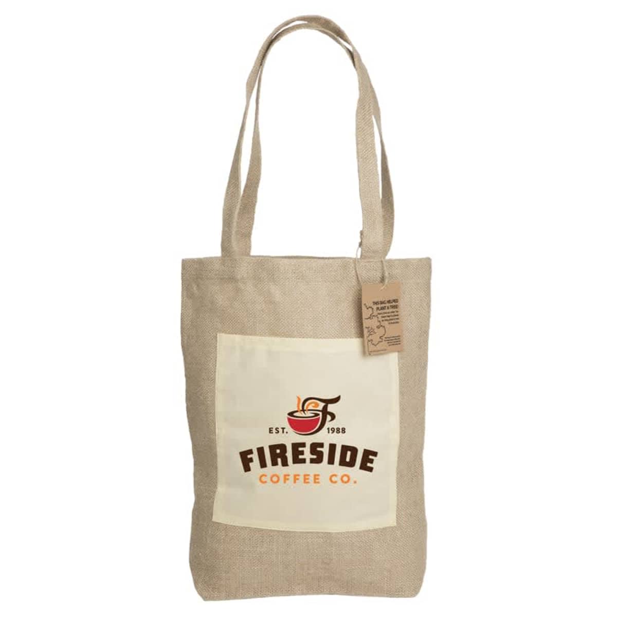 Beige canvas tote bag with long handles and a front pocket. The pocket displays a logo reading Fireside Coffee Co. Est. 1988 with a steaming coffee cup icon. A brown tag is attached to one handle.
