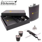 Bartender set with black box displaying Golden Bar logo. Includes a flask, funnel, corkscrew, and two shot cups. Modern Alchemist logo with cocktail elements is visible at the top left. Perfect for mixology and cocktail enthusiasts.