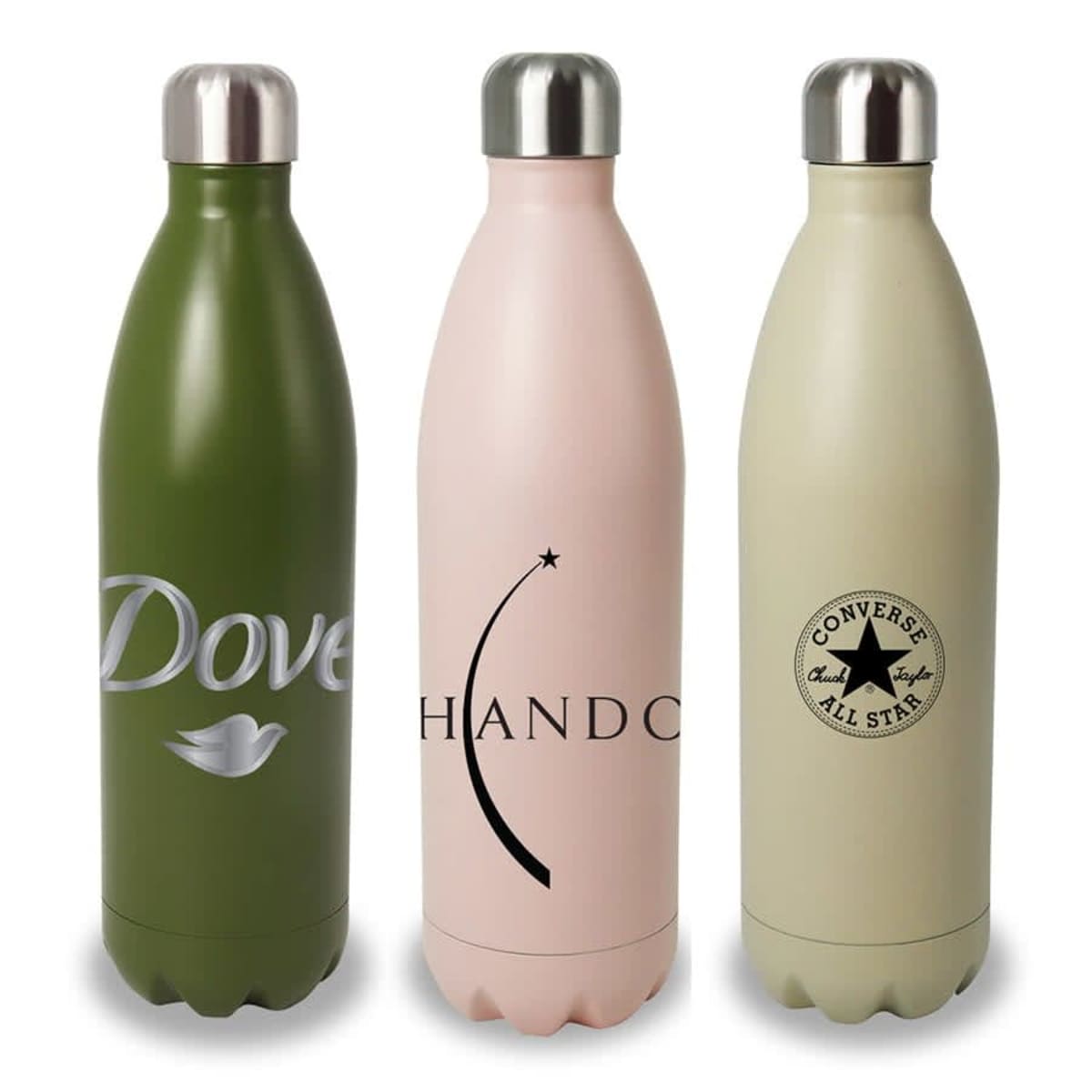 Three insulated water bottles are standing side by side. The first is green with Dove branding, the second is pink with Chando branding and a star graphic, and the third is beige with a Converse All Star logo. Each has a metal cap.