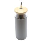 A tall, gray, insulated tumbler with a wooden lid and a metal straw. The lid has a small round opening for the straw, which is inserted and angled slightly. The tumbler appears minimalist and sleek.