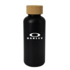 A black water bottle with a cork lid featuring the Oakley logo in white on its front. The bottle has a sleek, matte finish.