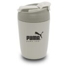 A beige insulated travel mug with a flip-top lid, featuring the PUMA logo and website puma.com printed in black on the side.