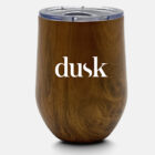 A wooden textured insulated tumbler with a clear plastic lid. The word dusk is printed in white on the front.