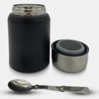 Black insulated food jar with a stainless steel lid and a foldable metal spoon. The lid is open, showing the interior. The spoon is placed in front of the jar.