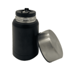 A black insulated food container with a stainless steel lid is standing upright. The lid is off and placed beside the container. The container has a small flip-top opening for easy access.