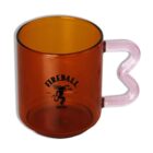 A transparent amber mug with a heart-shaped handle. The mug features the Fireball Whisky logo, including a stylized dragon graphic. The handle is clear with a pinkish tint.