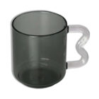 A transparent dark gray mug with a clear, heart-shaped handle is shown against a white background.