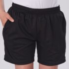 A person wearing black athletic shorts with their hand in one pocket, standing against a plain background. The shorts have an elastic waistband and a relaxed fit.
