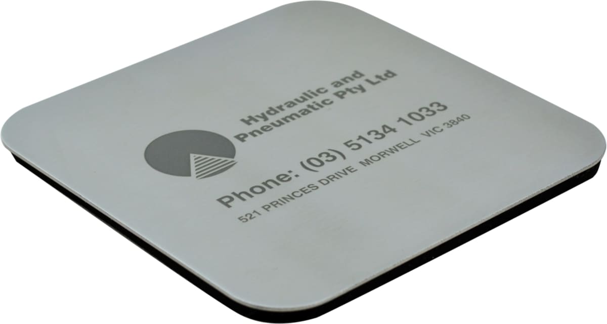 A square silver coaster with black text displaying Hydraulic and Pneumatic Pty Ltd along with a phone number and address: 521 Princes Drive, Morwell, VIC 3840.
