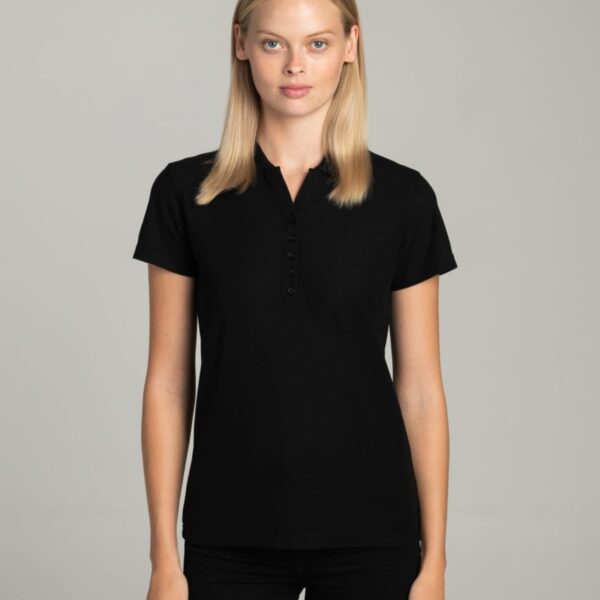 A woman in a black short-sleeve polo shirt stands facing forward against a plain background.