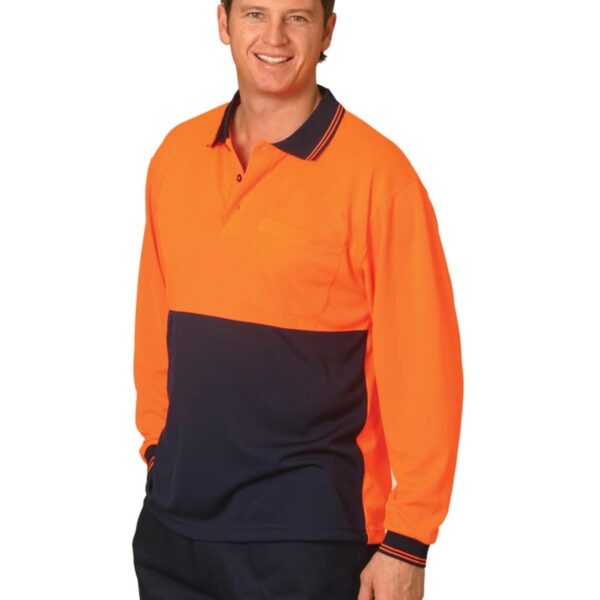 A person wearing an orange and navy long-sleeve polo shirt stands against a white background, smiling. The shirt has a pocket on the chest and a collar with stripes.