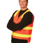 A person wearing a bright orange safety vest with yellow reflective stripes, crossing their arms and smiling against a white background.