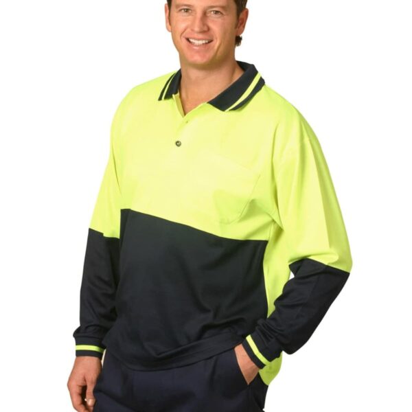 A person wearing a high-visibility, long-sleeve polo shirt with a lime green top and dark blue bottom section. They are smiling with one hand in their pocket, standing against a plain background.