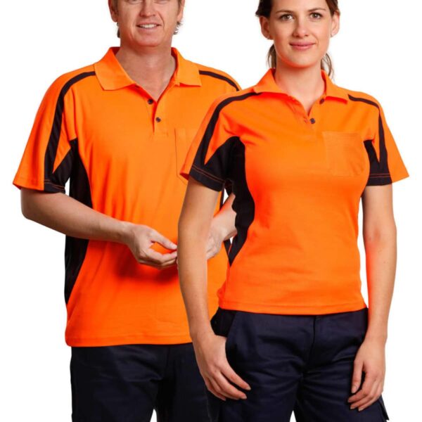 Two people wearing orange polo shirts with black accents and dark pants stand side by side. They are smiling, and their outfits appear to be uniforms.