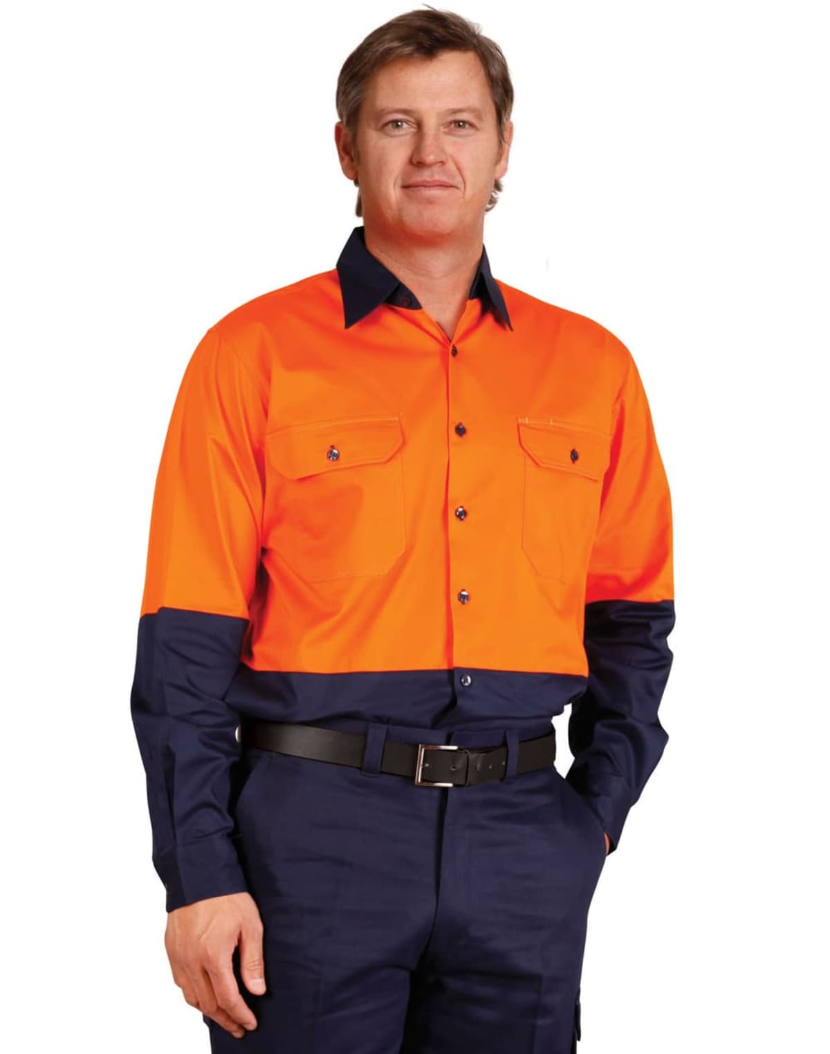 A man wearing an orange and navy work uniform stands with one hand in his pocket. The shirt is bright orange with navy cuffs and collar, and he is wearing matching navy pants.