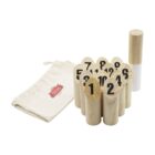 Wooden numbered skittles are arranged in a group, with numbers ranging from 1 to 12. A white and wooden stick is beside them. A beige drawstring bag with a red and white logo is on the left.