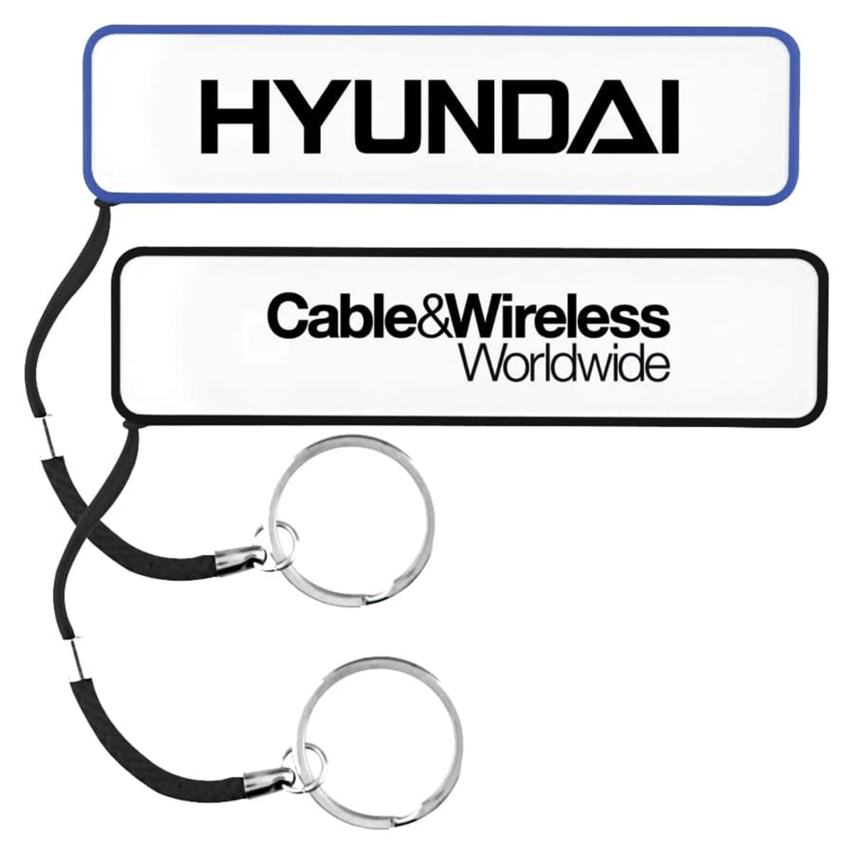 Two keychains with rectangular tags. The top tag is white with a blue border displaying the HYUNDAI logo. The bottom tag is white with a black border featuring the Cable&Wireless Worldwide logo. Both tags have black cords and silver keyrings.