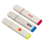 Three rectangular highlighters with rounded edges in beige cases. Each has a colored band and tip: pink with a Coca-Cola logo, blue with an ABC Australia logo, and yellow with a Kodak logo.