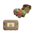 A small cardboard carton labeled Childcare Network holds six colorful egg-shaped crayons. The carton is shown open with the crayons visible, and closed with the label on top.