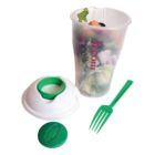 A plastic salad cup featuring a logo, filled with mixed greens and vegetables. The cup has a white lid with a green circular compartment for dressing. A matching green fork is included, resting beside the opened lid.