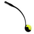 A black dog ball launcher with a yellow-green tennis ball in its curved holder. The handle has an ergonomic grip, designed for throwing balls long distances for pets. The brand name Royal Canin is printed on the handle.