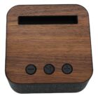 A compact device with a wood-textured top, featuring a rectangular slot and three black buttons below it. The buttons are labeled with minus, play/pause, and plus symbols. The sides are covered in a gray fabric material.