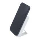 A smartphone resting on a white, angled wireless charging stand against a plain background.