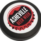 A round promotional item for Asheville Beer Week featuring a design of a red bottle cap with the event name in bold white and red lettering on a black and white background.